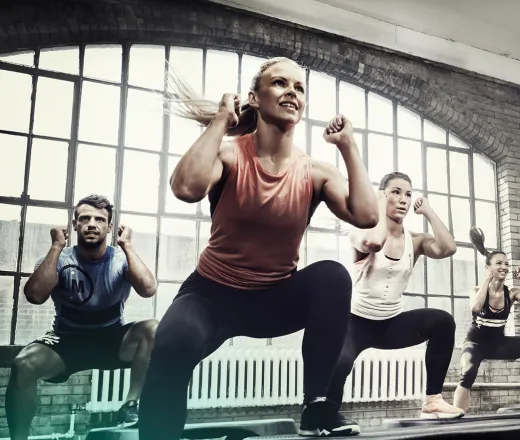 Group of men and women working out in a group exercise class - BodyStep by Les Mills